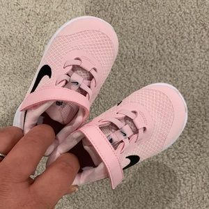 Pink and black check NIKE toddler running shoes.